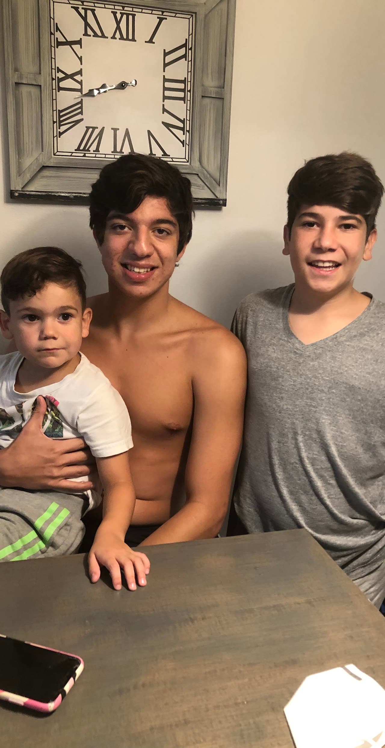 Ryan with his two younger brothers, smiling at the camera