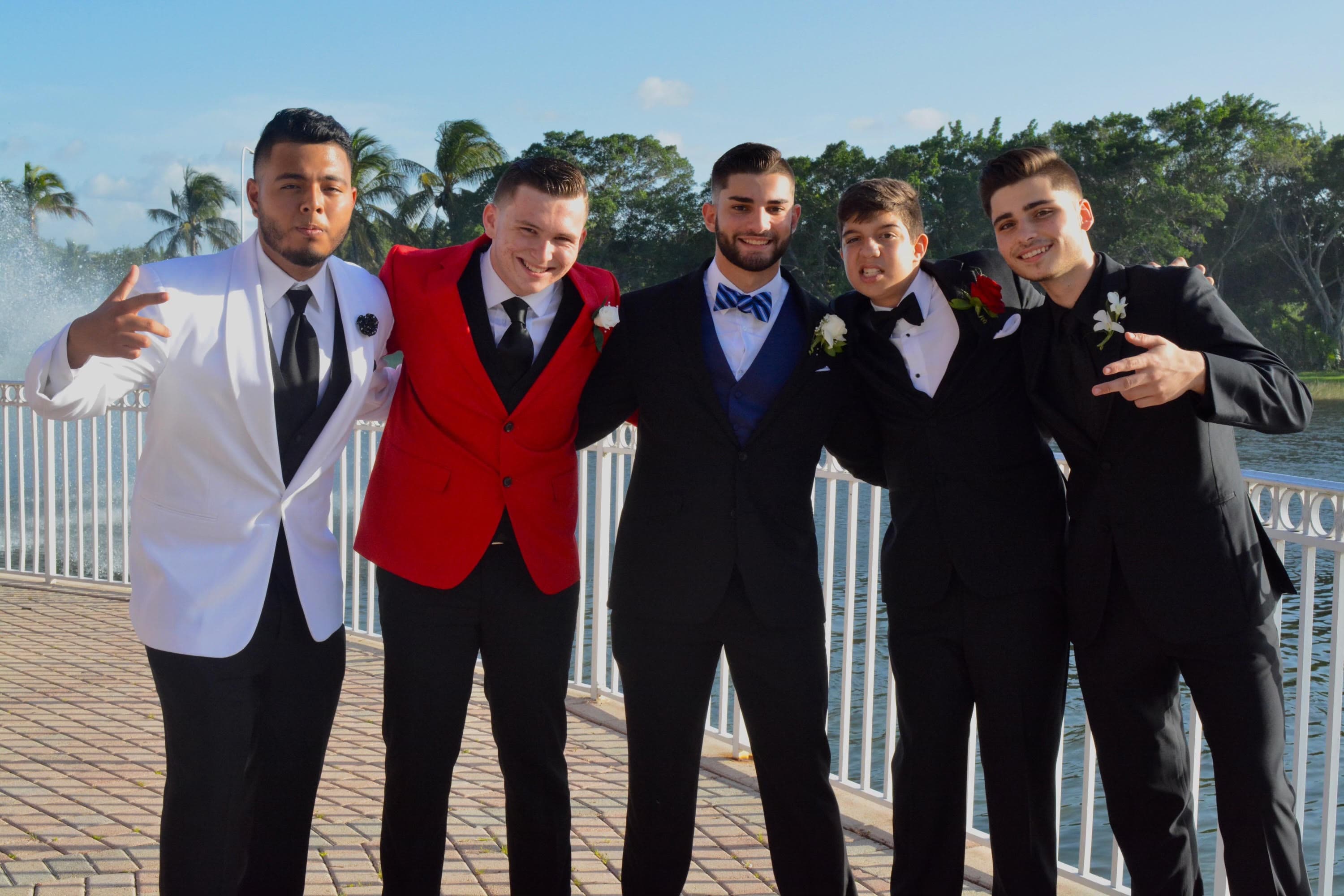 Ryan and his friends in tuxedos by the fountain at prom