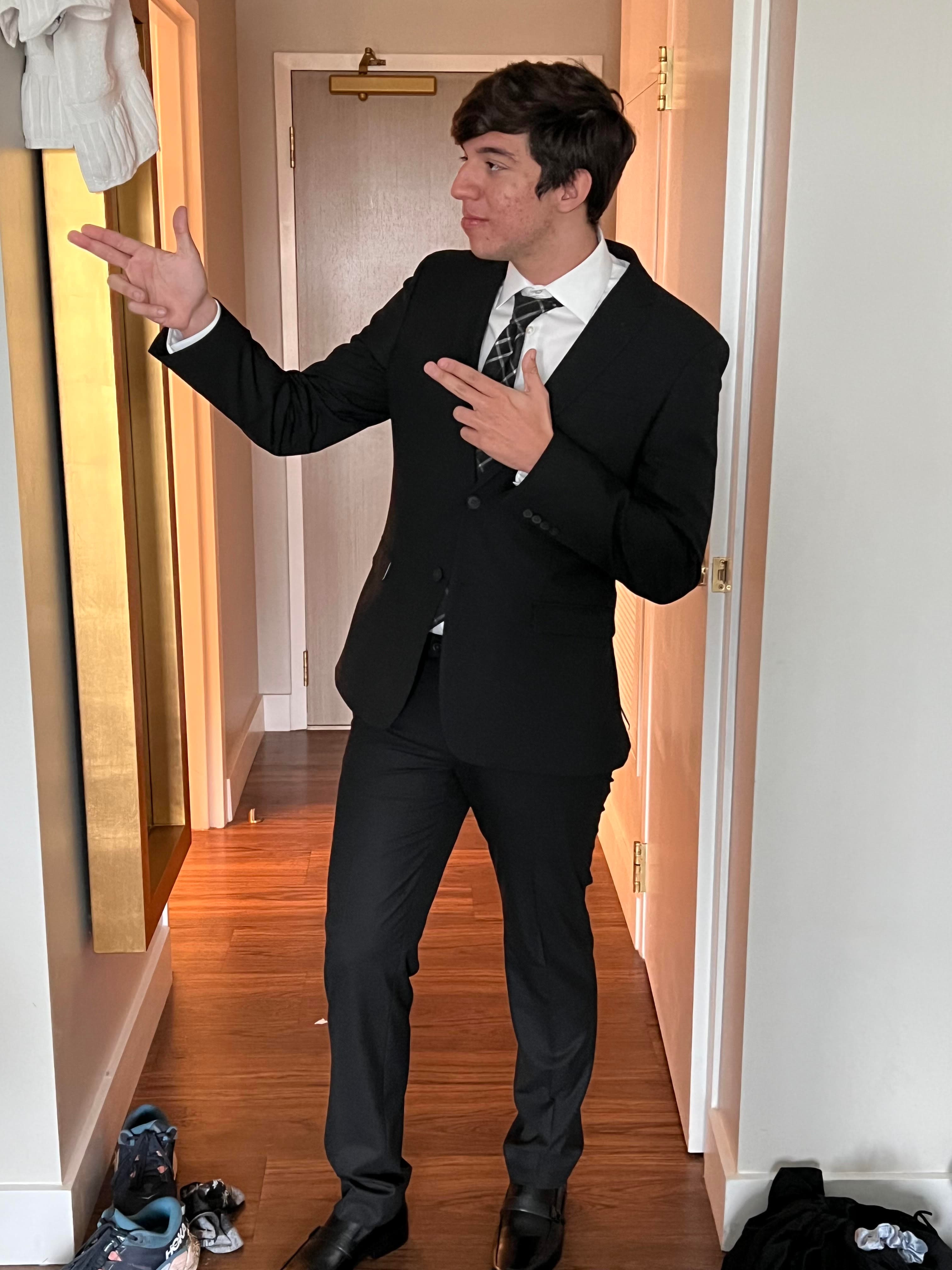 Ryan in a suit in the hallway, mid-gesture