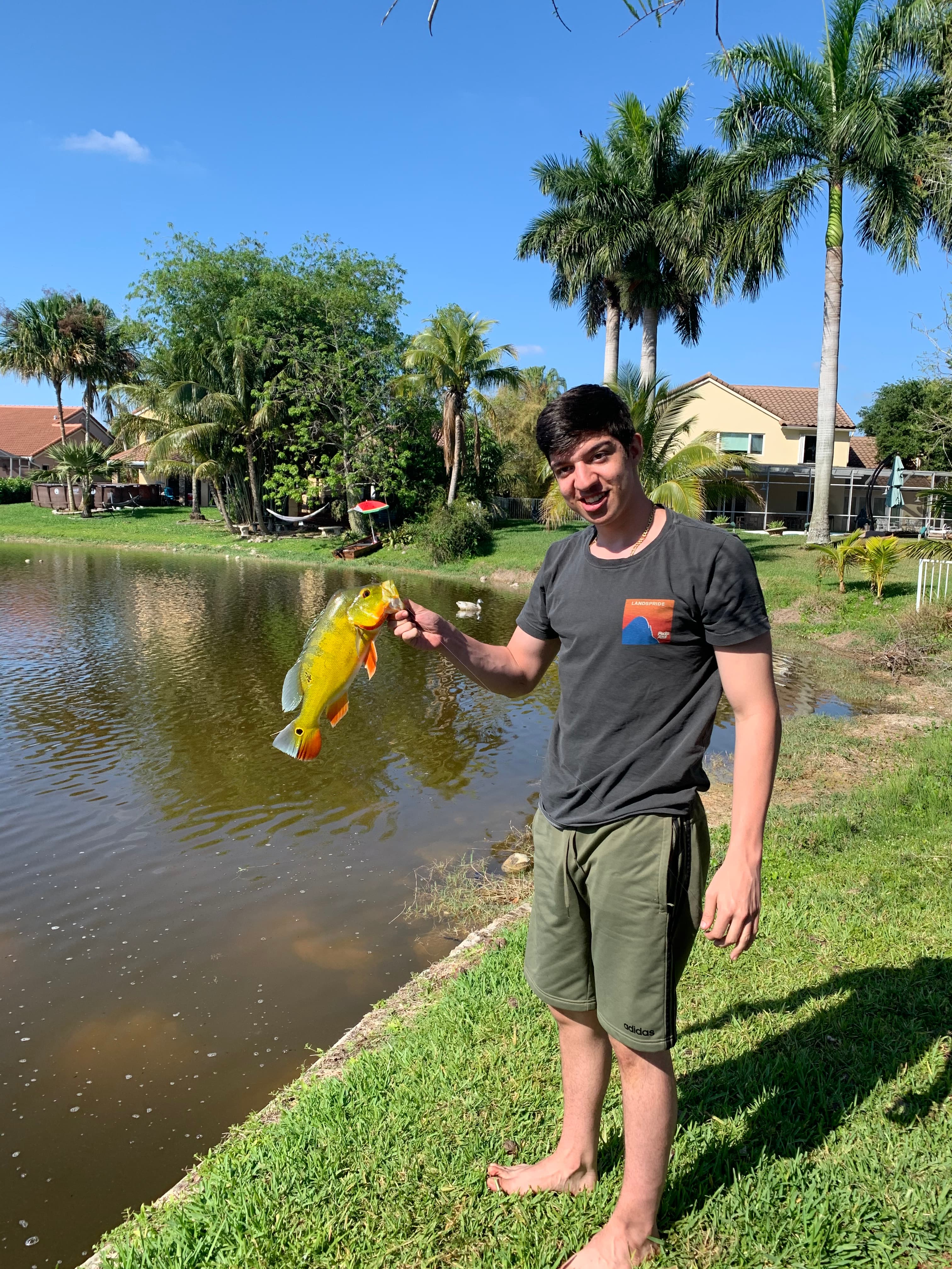 Ryan holding a fish he caught by the lake